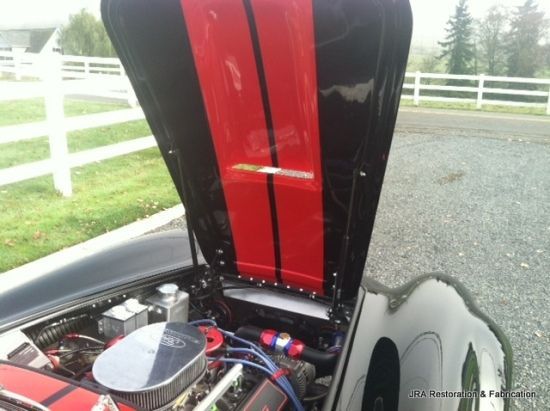 A black and red car with the hood open