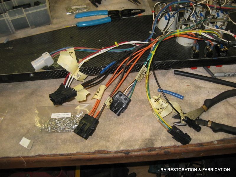 A bunch of wires are laying on a table with a sign that says jra restoration & fabrication