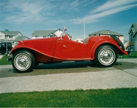 A red car is parked on the side of the road