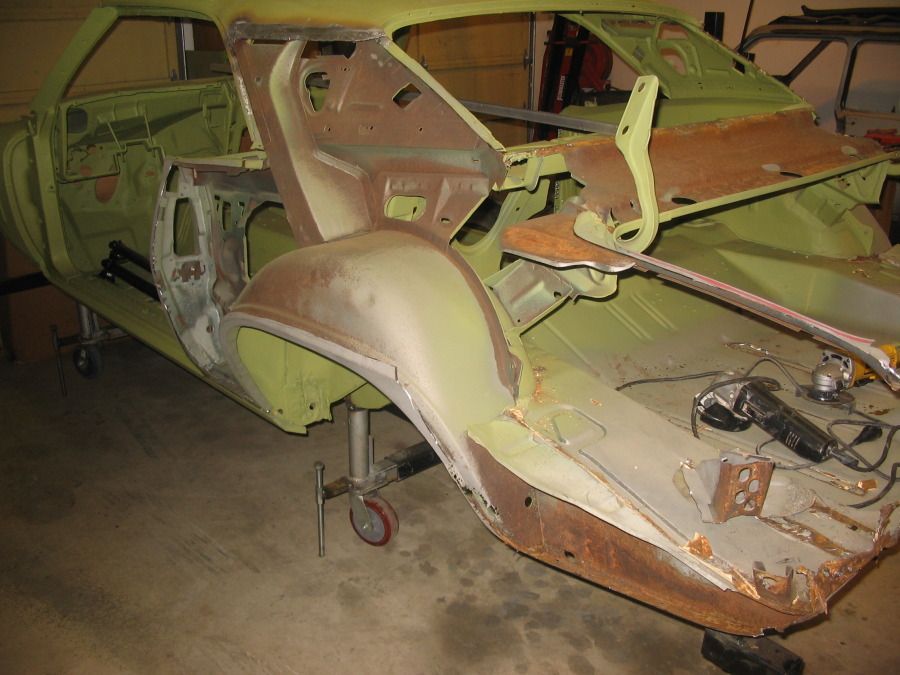 A green car is being built in a garage