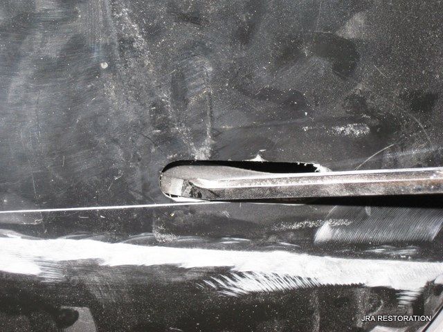 A black and white photo of a car door handle