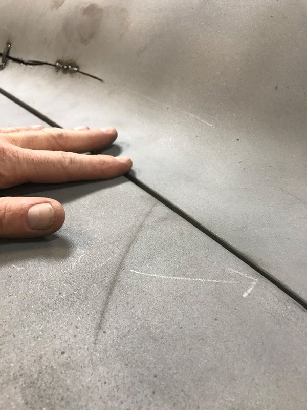 A person is holding a piece of metal with their fingers.