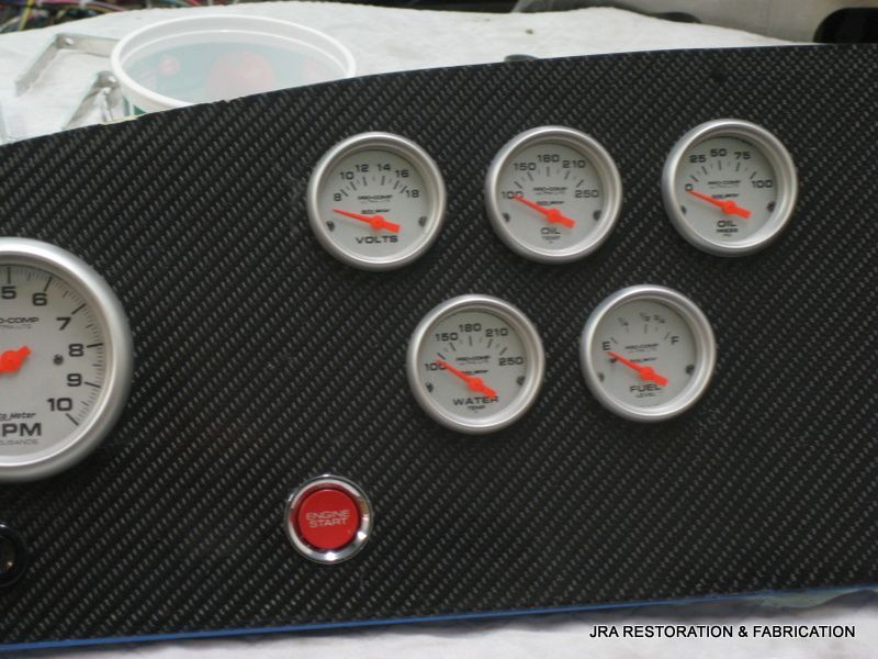 A dashboard with several gauges and a red stop button