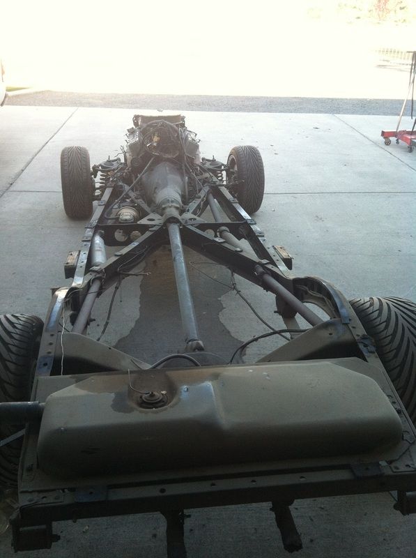 A car chassis is sitting in a parking lot