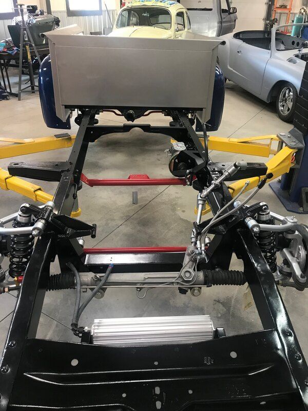 A car is sitting on top of a frame in a garage.