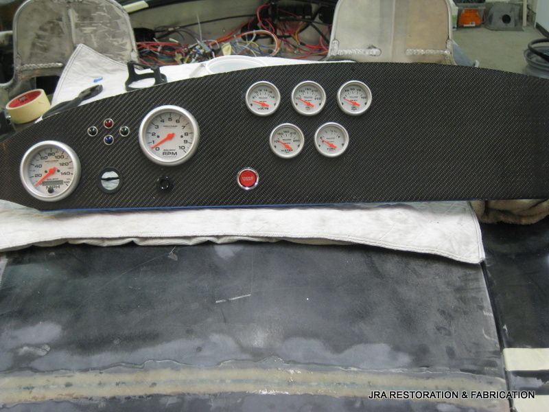 A black dashboard with a bunch of gauges on it