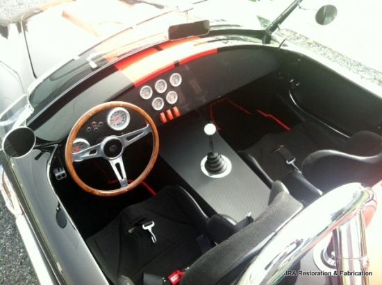 The inside of a car with a wooden steering wheel