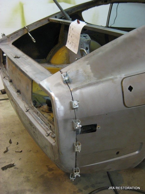 A car is being restored and has a piece of paper taped to it