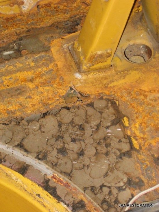 A close up of a rusty metal structure with a lot of dirt on it.