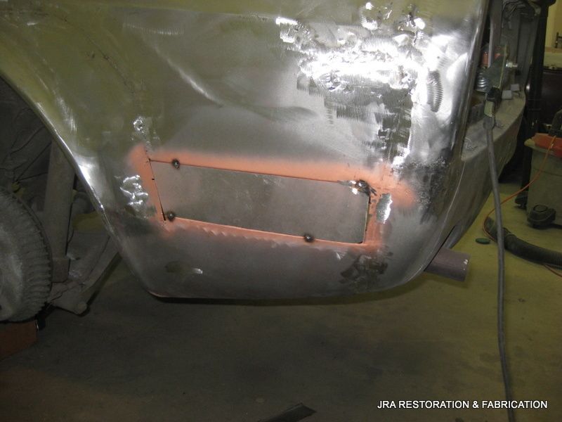 A piece of metal is being worked on in a garage.