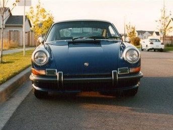 A blue car is parked on the side of the road