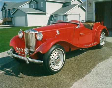 A red car is parked in front of a house
