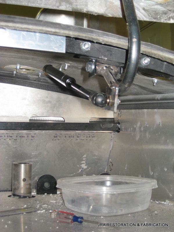 A clear plastic container is sitting on a metal surface next to a screwdriver.