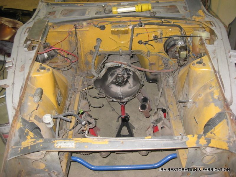 A yellow car is being worked on by a mechanic