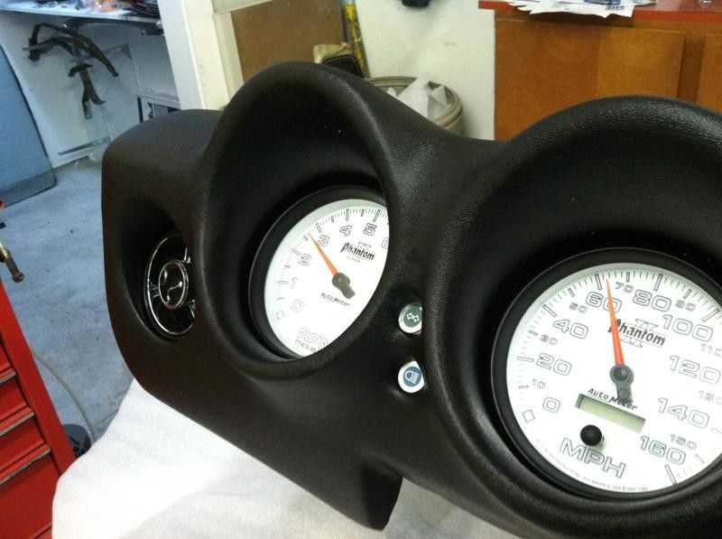 A car dashboard with a tachometer and a speedometer