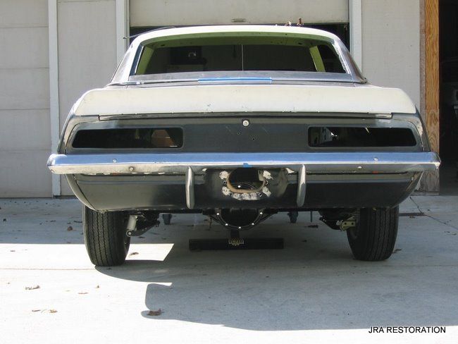 A white car is parked in front of a garage door
