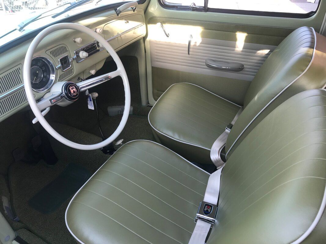 The interior of a car with green seats and a white steering wheel