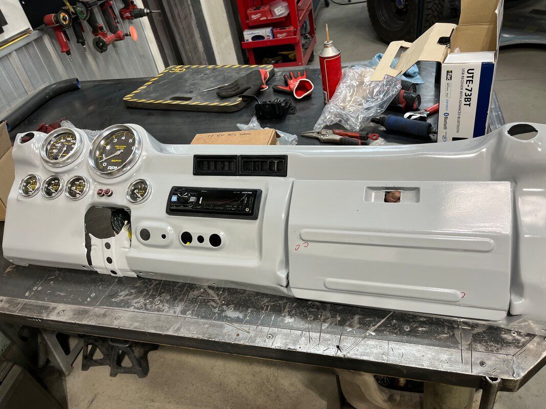 A white dashboard is sitting on top of a metal table.