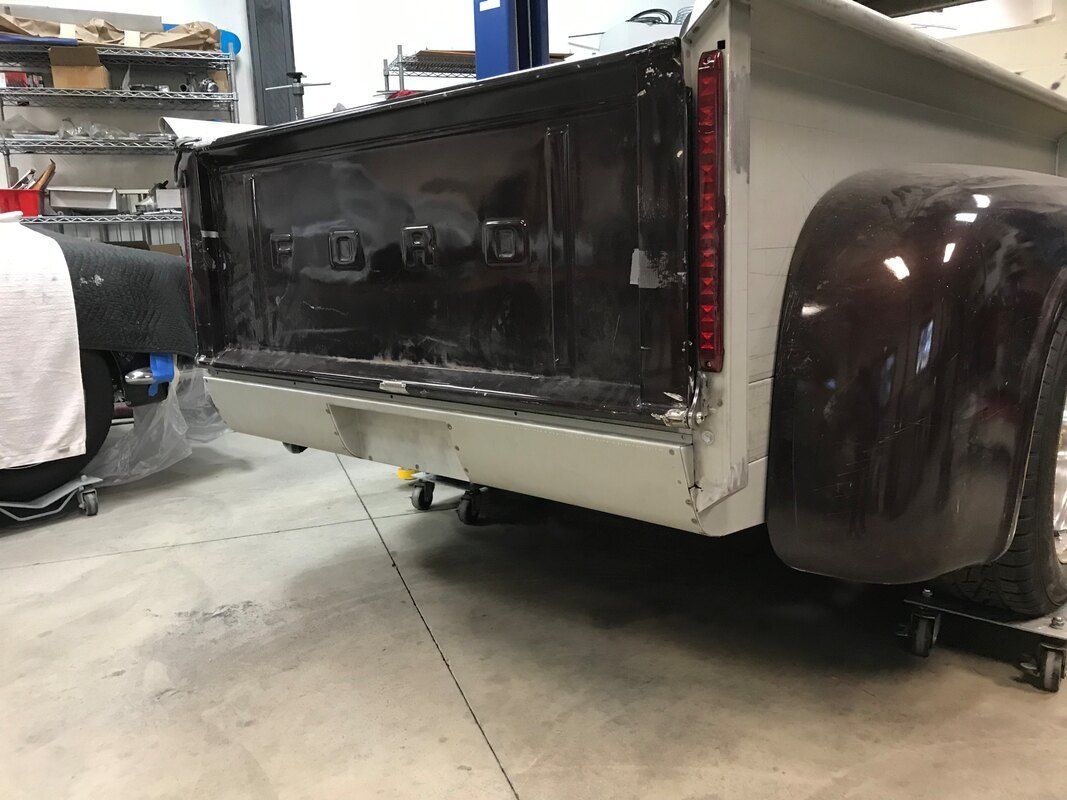 A truck is sitting on a concrete floor in a garage.