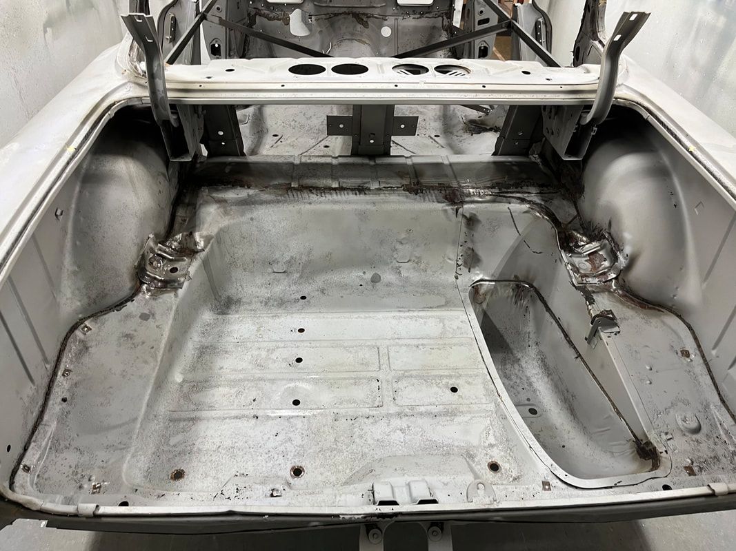 The trunk of a car is empty and ready to be painted.