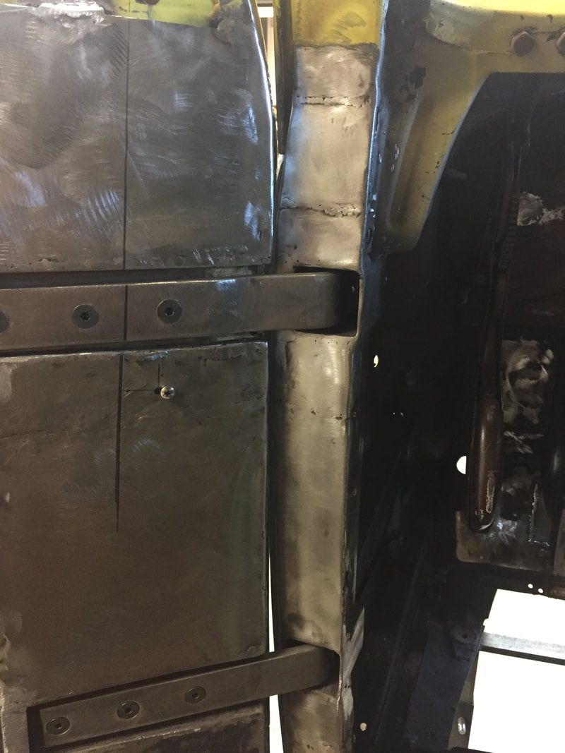 A close up of a metal structure with a yellow car in the background.