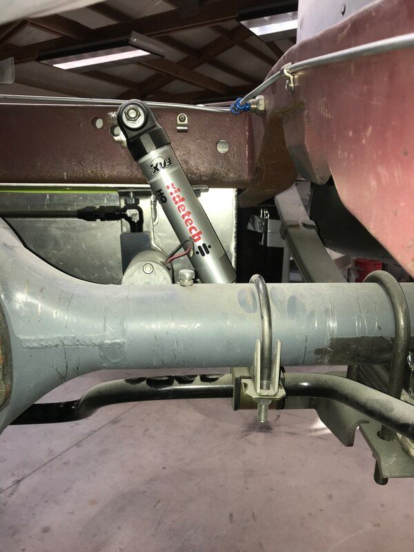 A close up of a shock absorber on the back of a truck