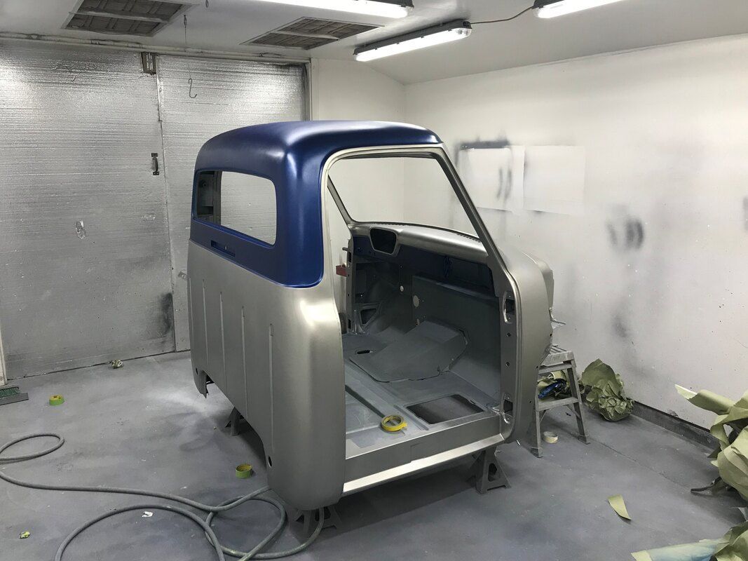 A car is being painted in a paint booth.