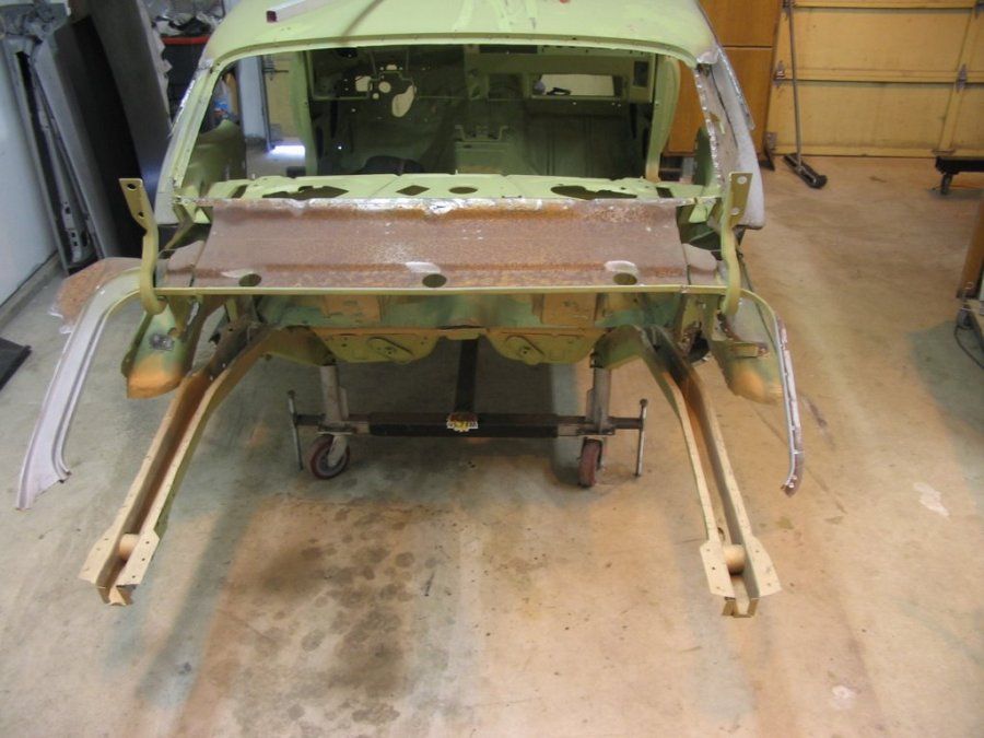 A green car is sitting on a cart in a garage