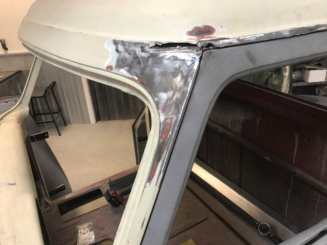 The roof of a car is being repaired in a garage.