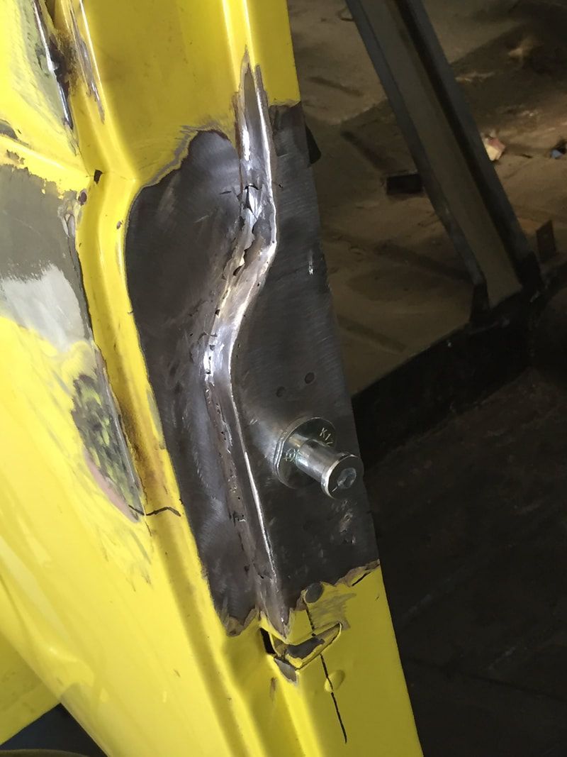 A close up of a yellow door with a metal bracket on it.