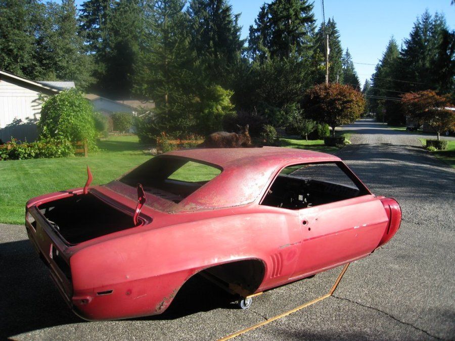 A red car is parked on the side of the road