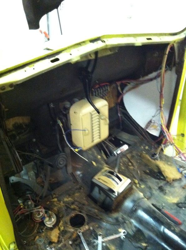 A yellow car is being worked on in a garage