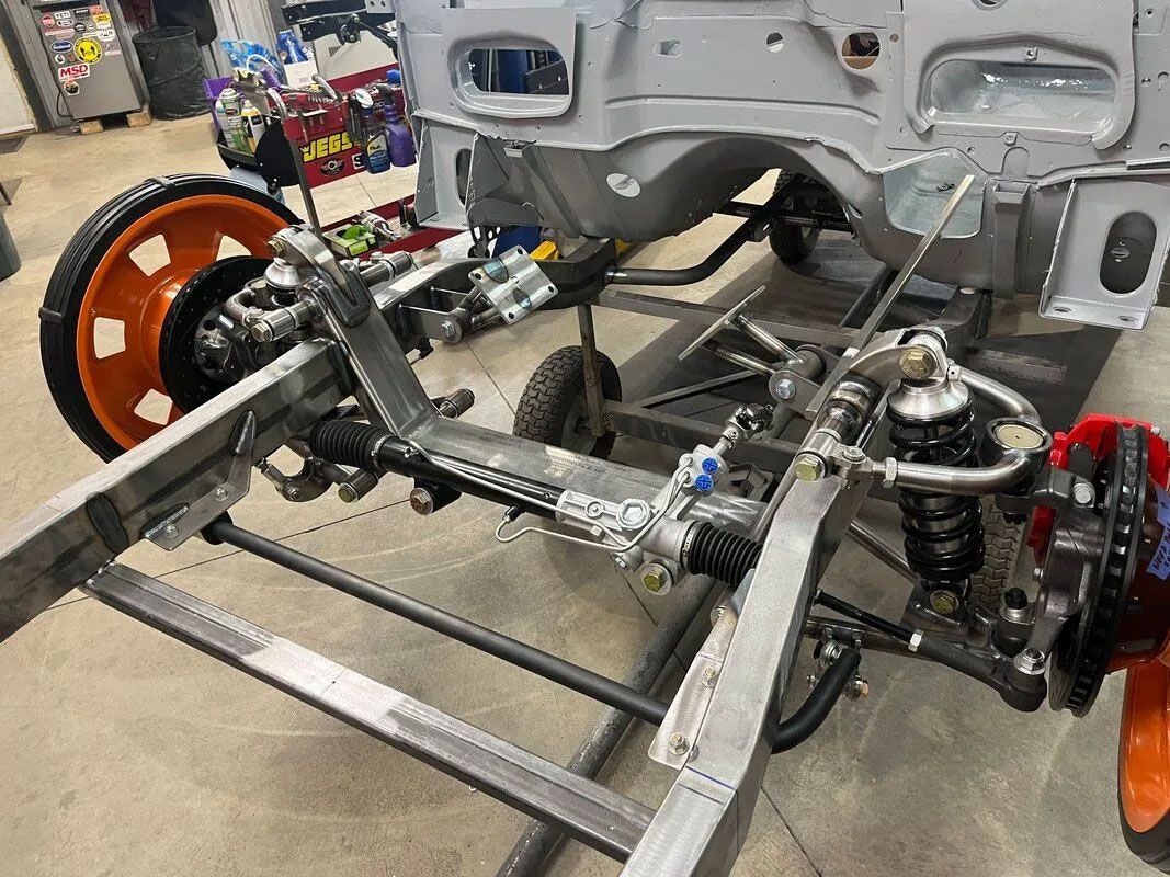 A car chassis is being built in a garage.