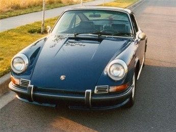 A blue porsche is parked on the side of the road
