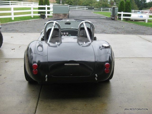 A black sports car is parked in a driveway