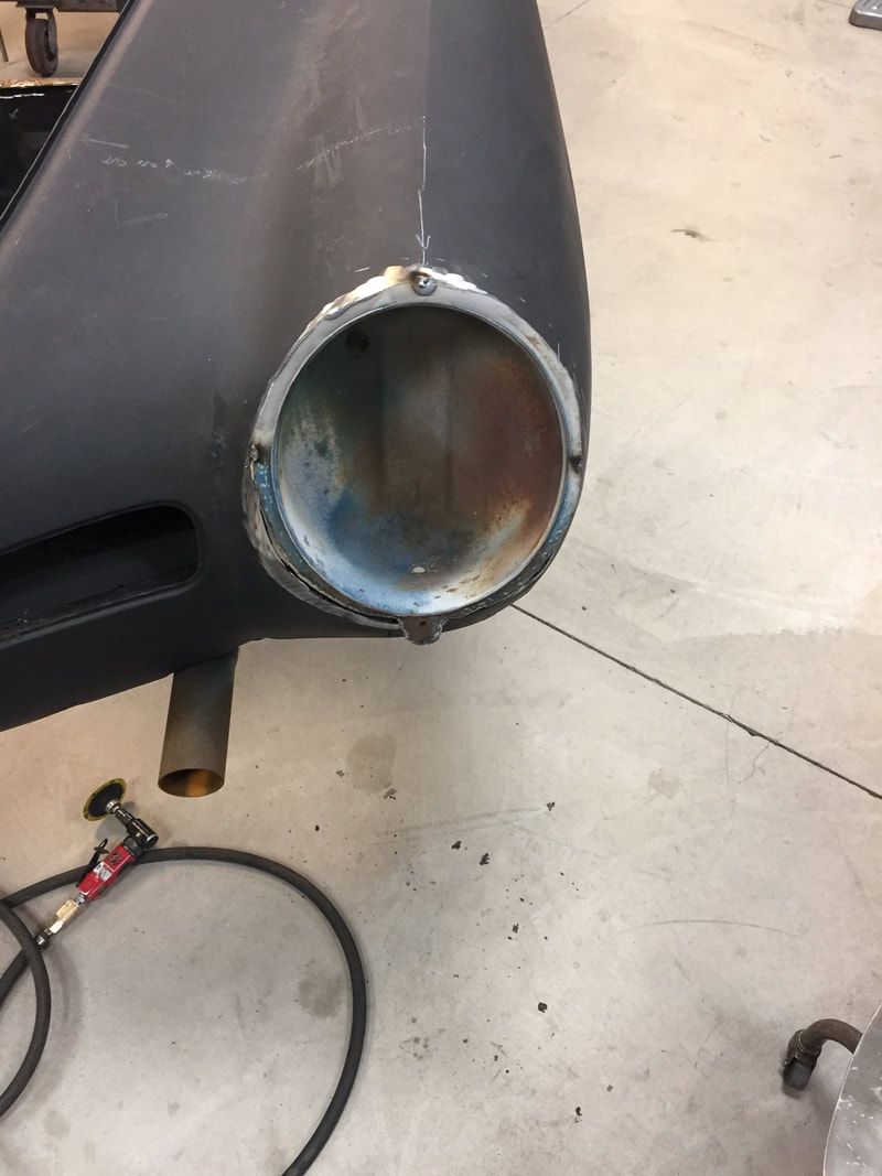 A metal pipe is sitting on the ground next to a hose.