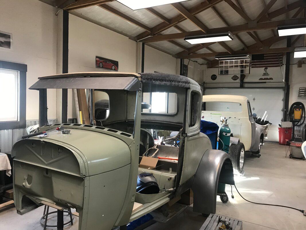 An old car is being restored in a garage.
