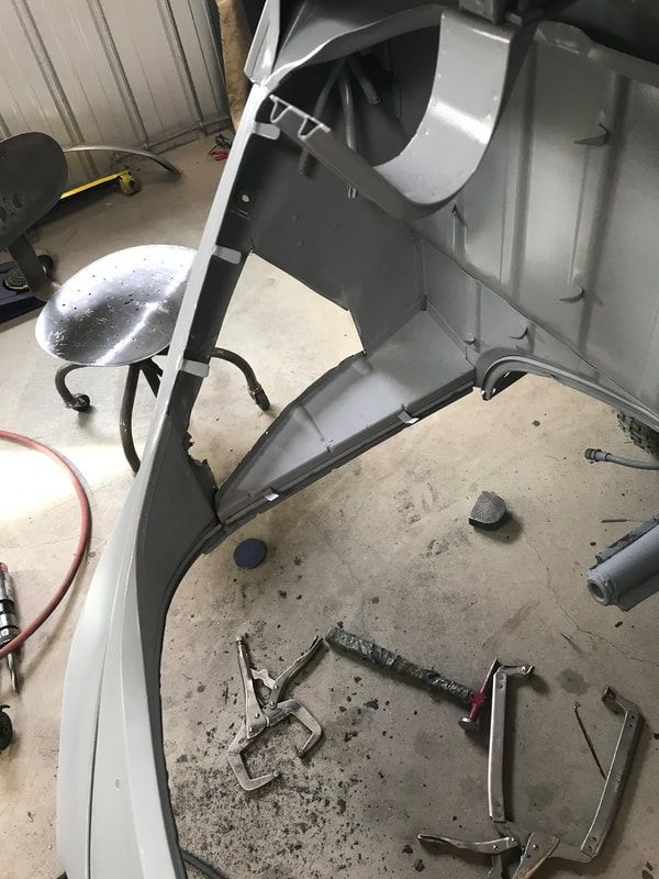 A piece of metal is being worked on in a garage