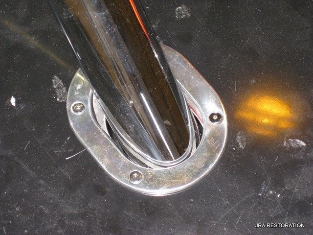 A close up of a stainless steel pipe on a black surface