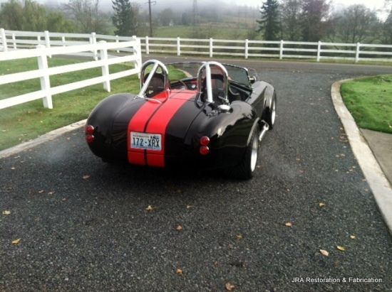 A black and red sports car is parked on a road