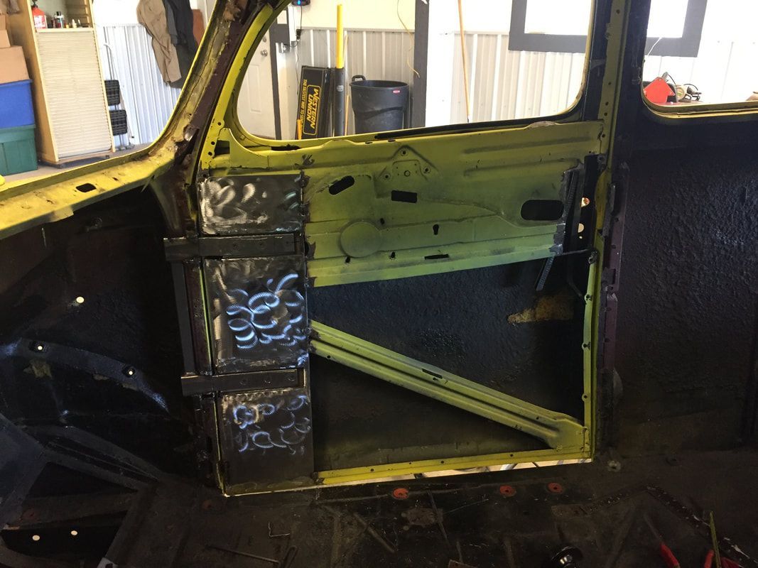 A yellow car is being built in a garage.