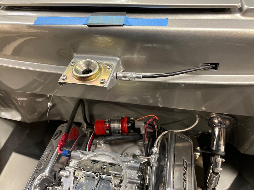 A close up of a car engine with a fuel pump attached to it.