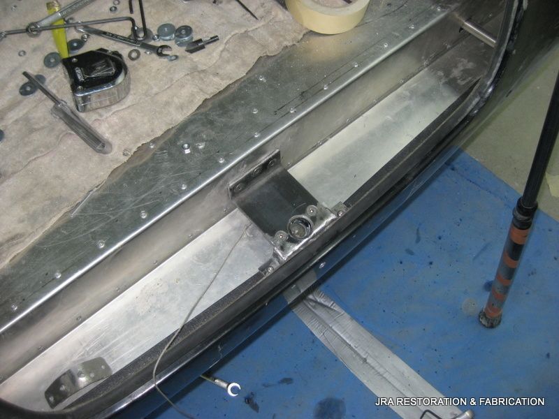 A piece of metal is being worked on with a tape measure