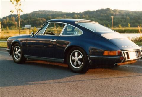 A blue porsche is parked on the side of the road