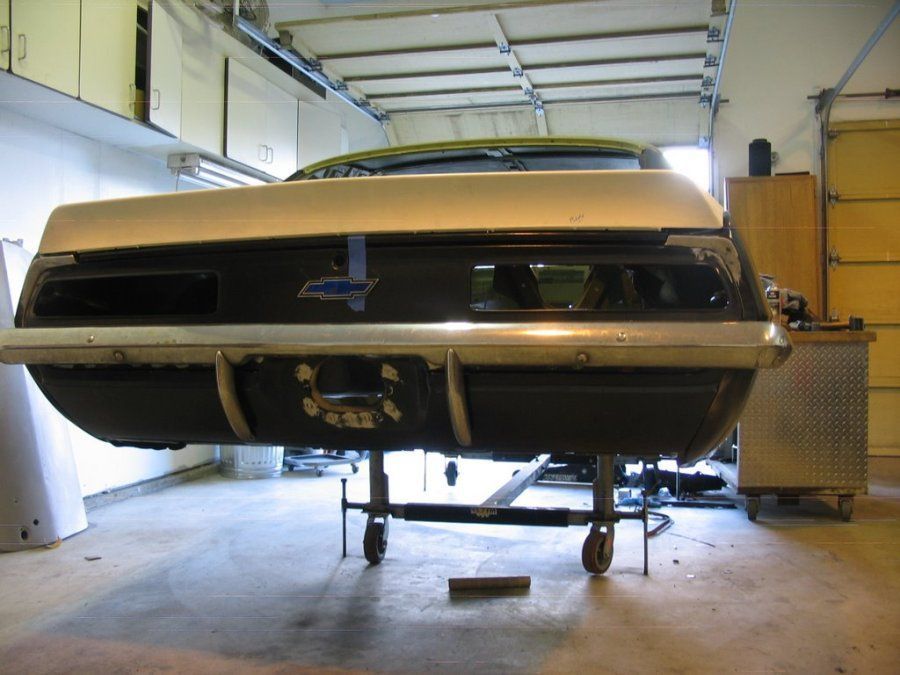 A chevrolet car is sitting on a cart in a garage