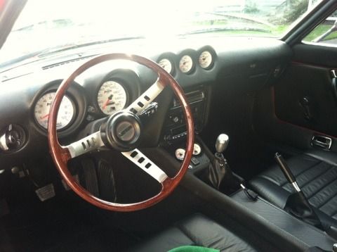 The inside of a car with a wooden steering wheel
