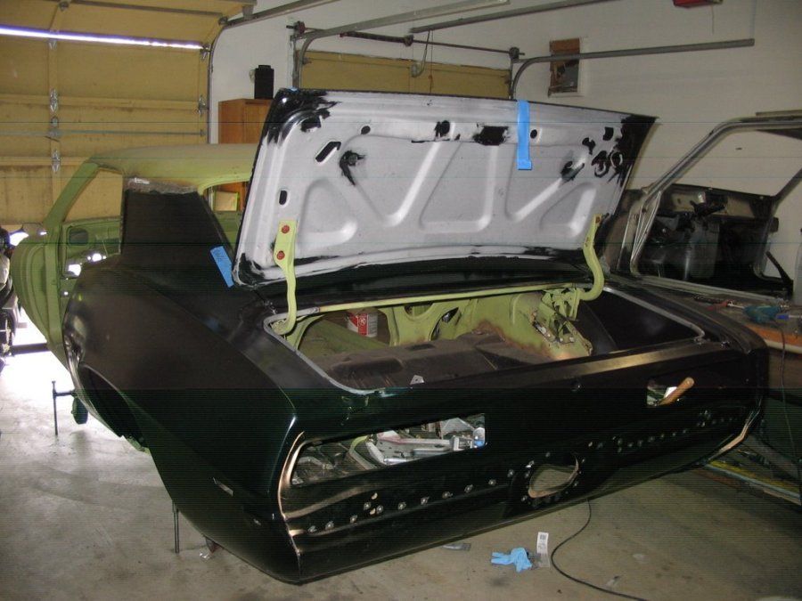 A black car with the trunk open in a garage