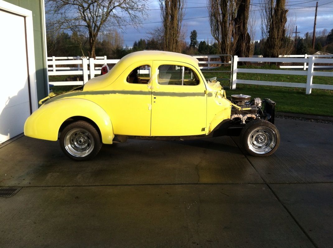 A yellow car is parked in front of a garage