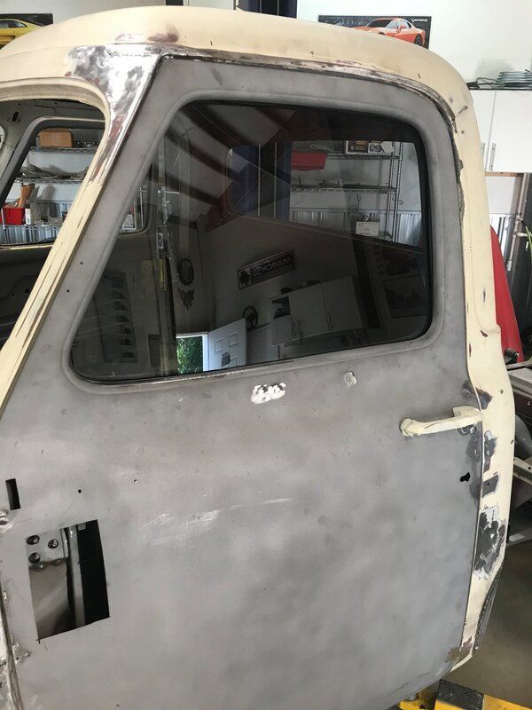 A truck door is being worked on in a garage.