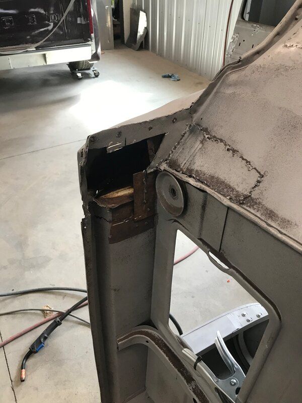 A piece of metal is being worked on in a garage